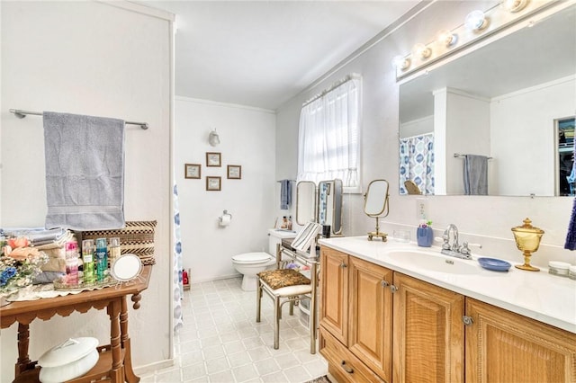 bathroom featuring tile patterned floors, crown molding, vanity, and toilet