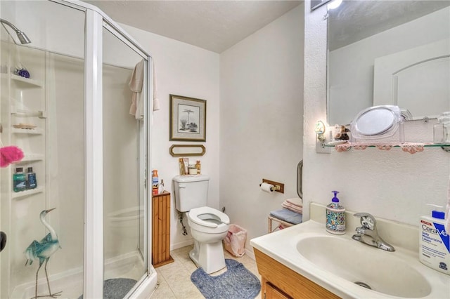 bathroom with tile patterned flooring, vanity, toilet, and walk in shower