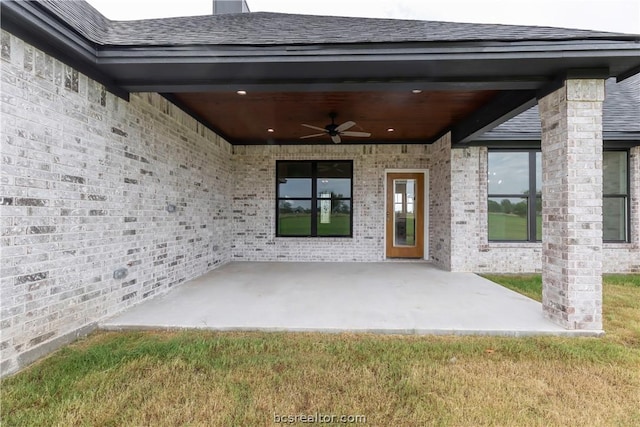 view of exterior entry with ceiling fan and a patio