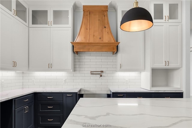 kitchen with pendant lighting, white cabinetry, and custom range hood