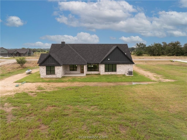 view of front of home with a patio area, central air condition unit, and a front lawn