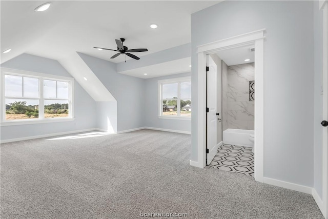 bonus room with light carpet, plenty of natural light, and ceiling fan