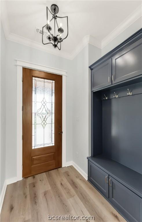 mudroom featuring a chandelier, light wood-type flooring, and crown molding