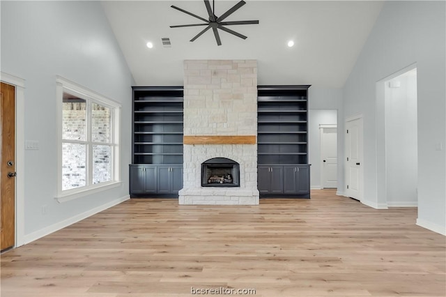 unfurnished living room featuring a stone fireplace, ceiling fan, high vaulted ceiling, and light wood-type flooring