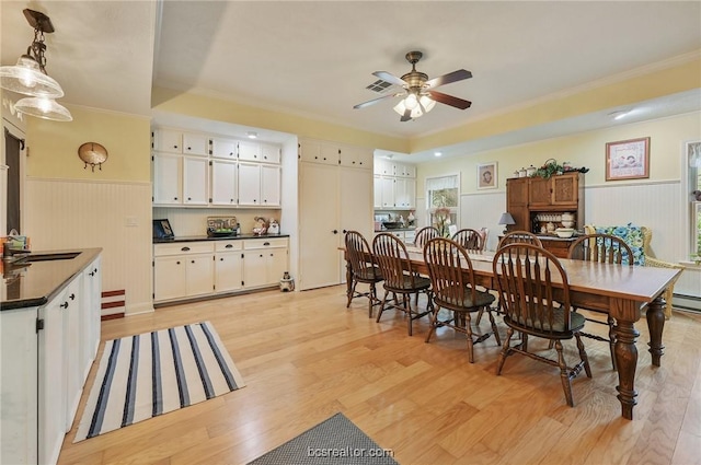 dining area with ceiling fan, crown molding, sink, and light hardwood / wood-style flooring