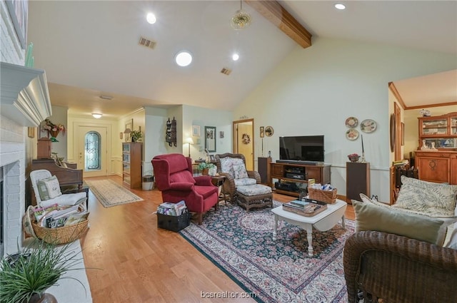 living room with beamed ceiling, light hardwood / wood-style floors, high vaulted ceiling, and a fireplace