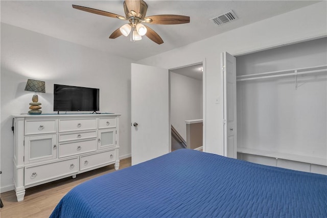 bedroom with visible vents, light wood-type flooring, a closet, baseboards, and ceiling fan