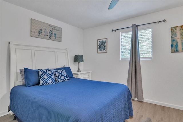 bedroom featuring light wood-style floors, a ceiling fan, and baseboards