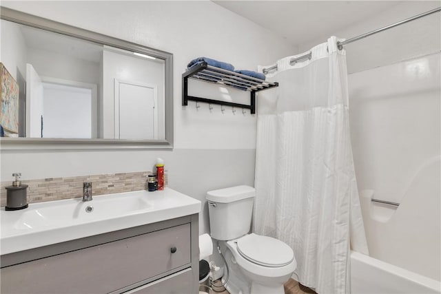 bathroom with toilet, tasteful backsplash, vanity, and shower / bath combo with shower curtain