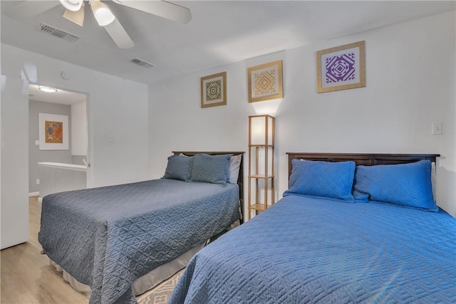bedroom featuring a ceiling fan, wood finished floors, and visible vents
