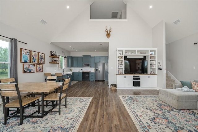 9159 Fm 1362 N, Caldwell, TX 77836 - dining area featuring high vaulted ceiling, dark wood finished floors, stairway, and recessed lighting
