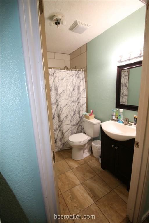 bathroom featuring curtained shower, vanity, and toilet