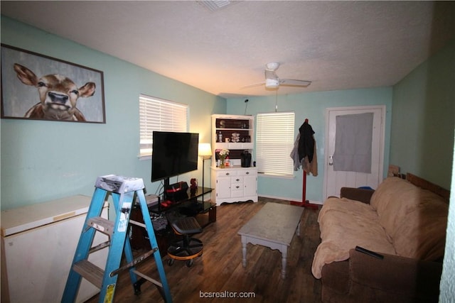 living room with ceiling fan and dark wood-type flooring