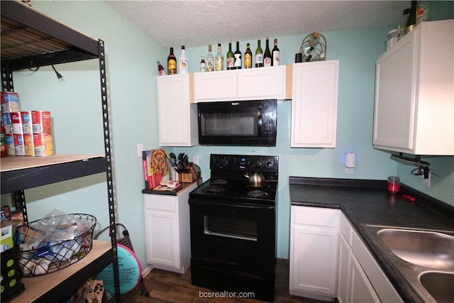 kitchen with a textured ceiling, dark wood-type flooring, sink, black appliances, and white cabinets