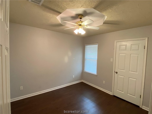 spare room with ceiling fan, dark hardwood / wood-style flooring, and a textured ceiling