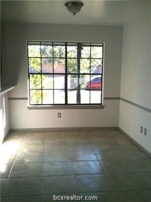 tiled empty room with a wealth of natural light