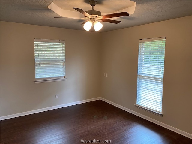 empty room featuring a textured ceiling, dark hardwood / wood-style floors, and ceiling fan