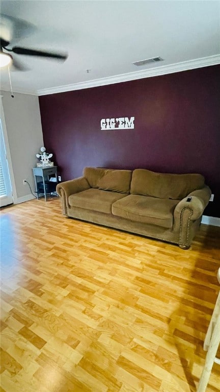 unfurnished living room featuring an accent wall, crown molding, and wood finished floors