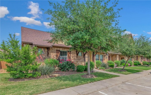 view of property hidden behind natural elements with a front yard