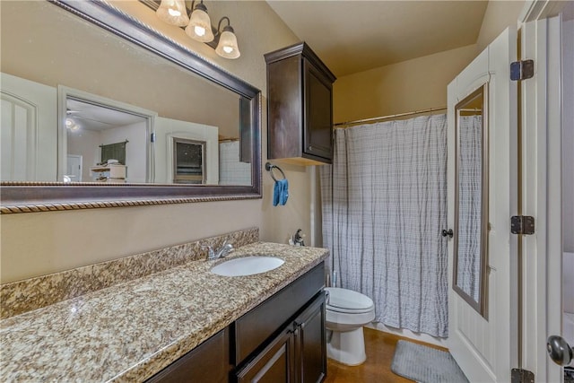 bathroom featuring walk in shower, toilet, and vanity