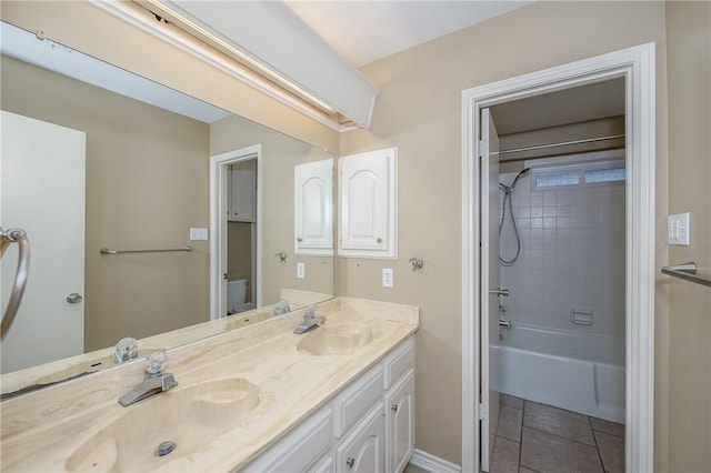 bathroom with toilet, tile patterned flooring, double vanity, and a sink