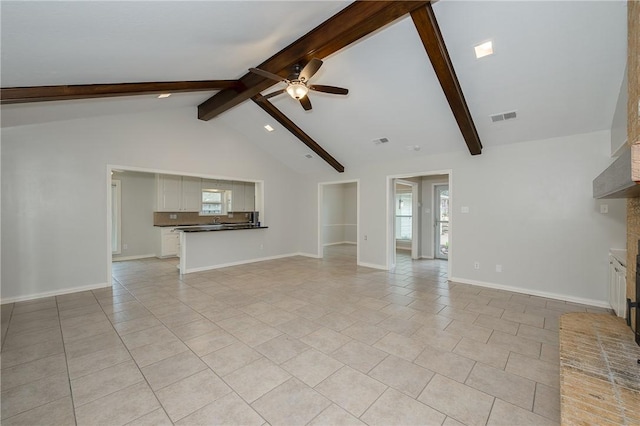 unfurnished living room with beam ceiling, a fireplace, visible vents, a ceiling fan, and baseboards