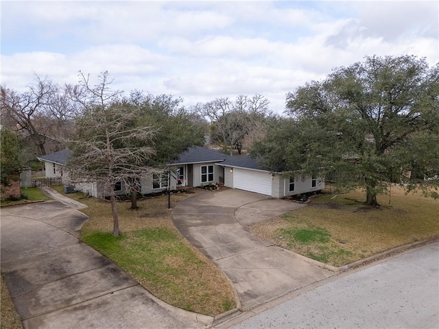 ranch-style home featuring a front lawn, driveway, and an attached garage