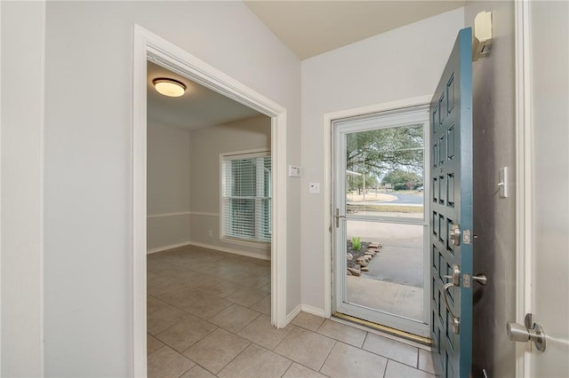 entryway with baseboards and light tile patterned flooring