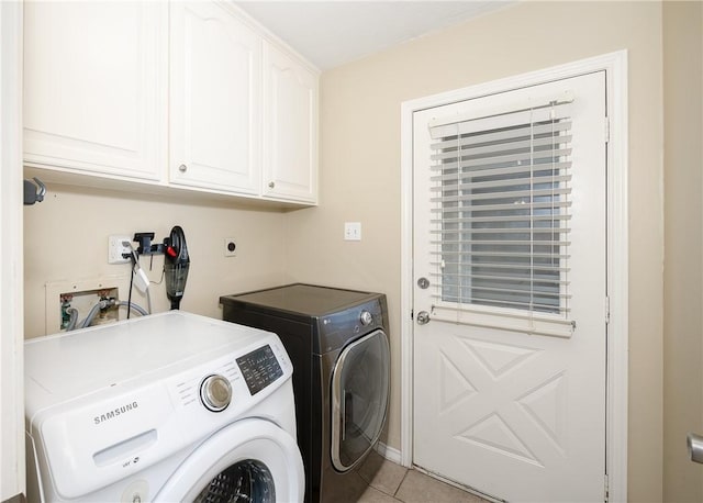 laundry room with cabinet space, washing machine and clothes dryer, and light tile patterned floors