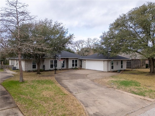 single story home with a garage, driveway, central AC unit, fence, and a front yard