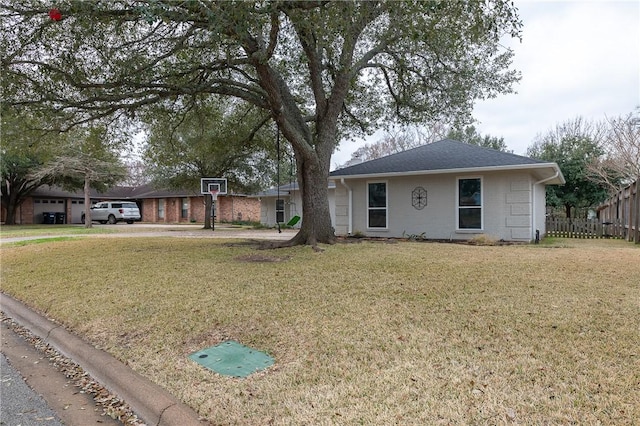 single story home featuring roof with shingles, fence, and a front yard