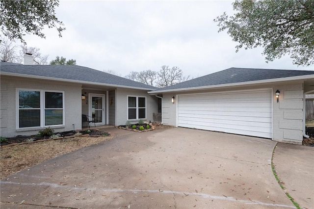 ranch-style house with brick siding, a chimney, a shingled roof, concrete driveway, and an attached garage