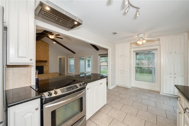 kitchen featuring vaulted ceiling with beams, white cabinets, wall chimney range hood, stainless steel electric range oven, and dark countertops