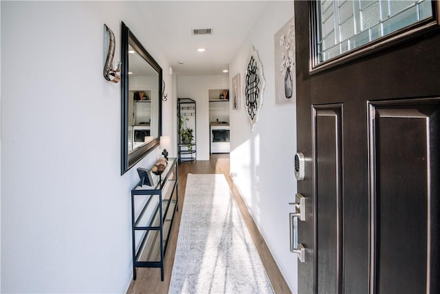 hall featuring baseboards, visible vents, wood finished floors, and recessed lighting