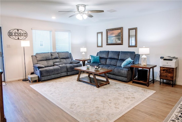 living area featuring baseboards, a ceiling fan, and light wood-style floors