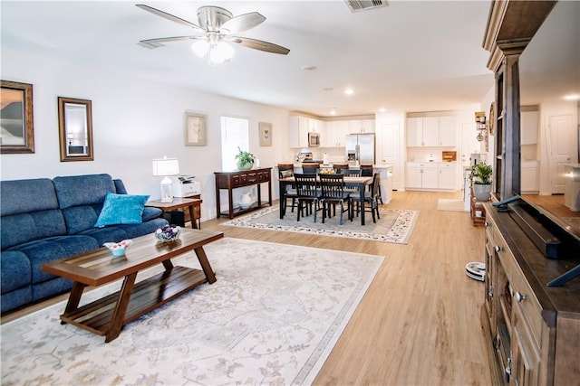 living room featuring visible vents, light wood-type flooring, ceiling fan, and recessed lighting