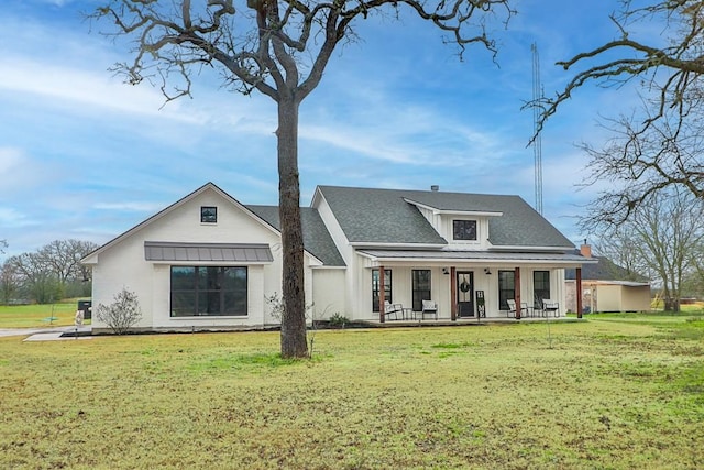 rear view of house featuring a yard and covered porch