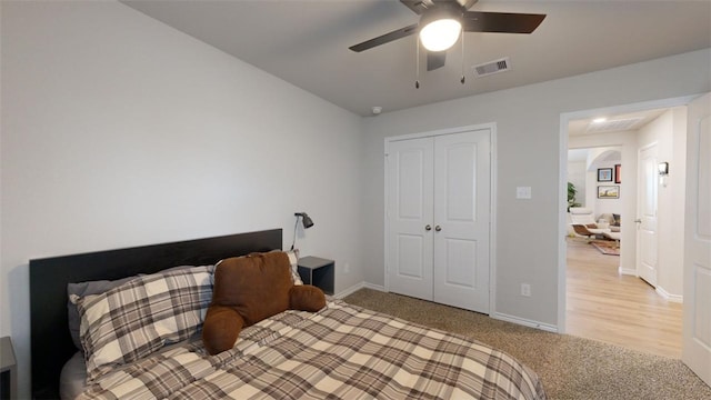 bedroom featuring ceiling fan, light colored carpet, and a closet