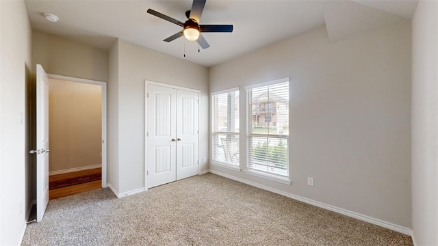 unfurnished bedroom featuring light colored carpet, a closet, and ceiling fan