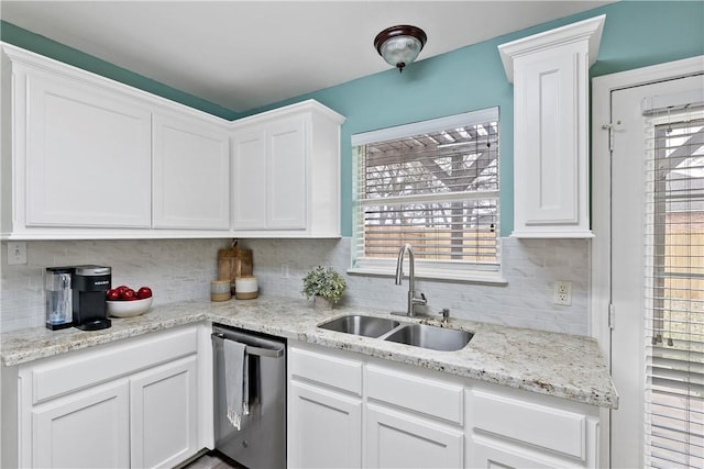 kitchen with a sink, backsplash, white cabinetry, and stainless steel dishwasher