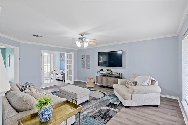 living room with ornamental molding, french doors, visible vents, and wood finished floors