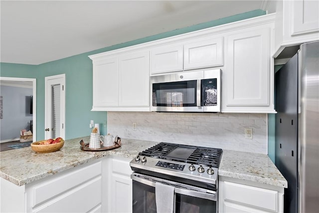 kitchen with stainless steel appliances, white cabinetry, and backsplash