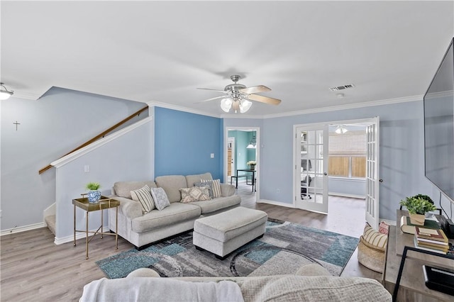 living room featuring stairway, visible vents, french doors, and wood finished floors