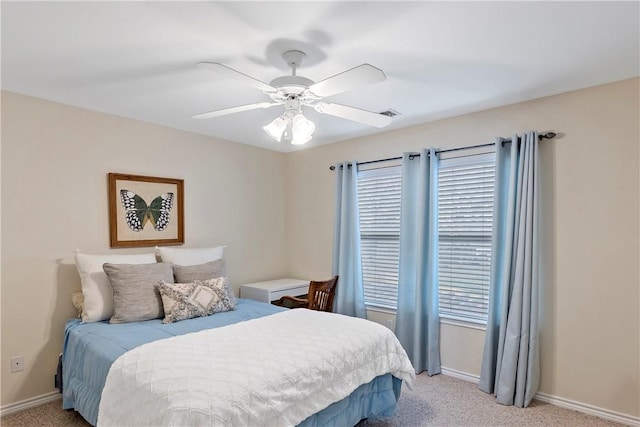 bedroom featuring light colored carpet, a ceiling fan, visible vents, and baseboards