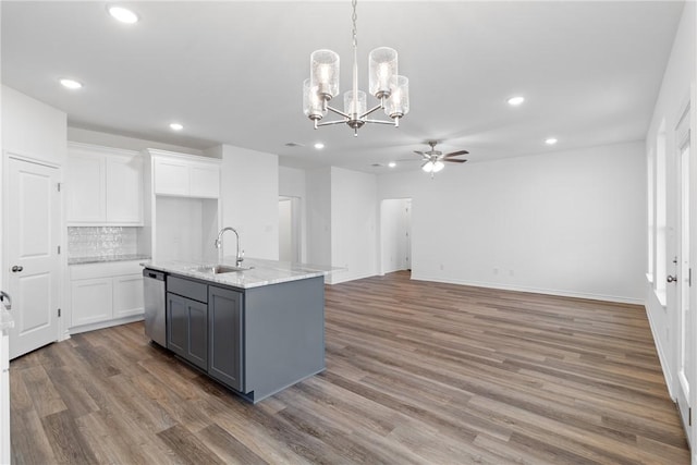 kitchen with white cabinets, backsplash, dishwasher, and a kitchen island with sink