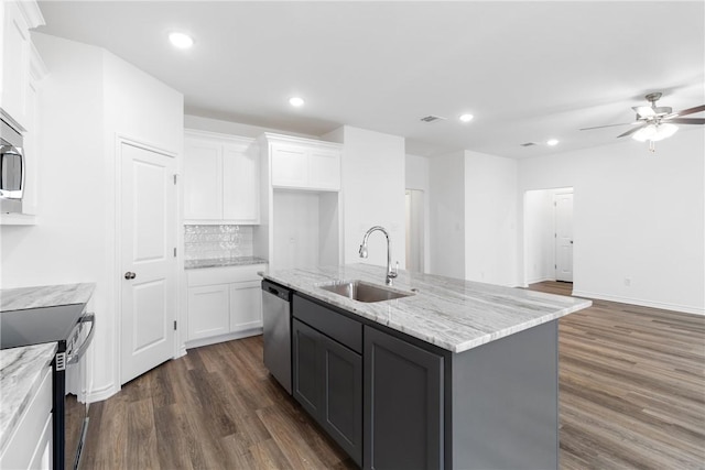 kitchen with electric stove, white cabinetry, sink, and an island with sink