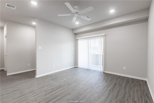 spare room featuring dark wood-type flooring and ceiling fan