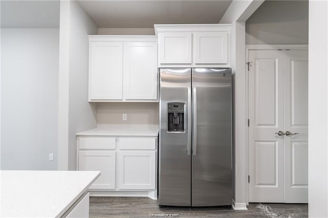 kitchen with white cabinets, hardwood / wood-style flooring, and stainless steel fridge