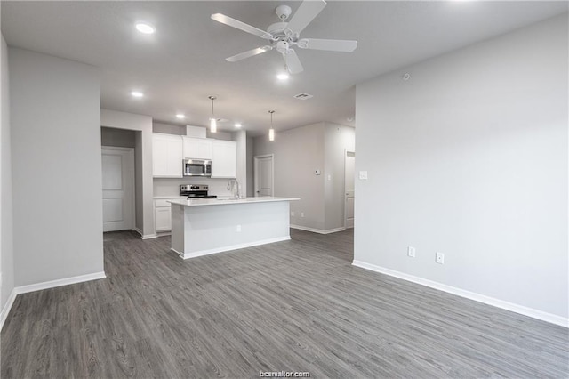 kitchen with stainless steel appliances, an island with sink, pendant lighting, dark hardwood / wood-style floors, and white cabinetry