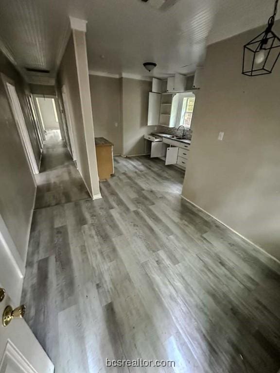 interior space with white cabinets, light wood-type flooring, and sink